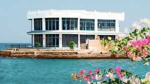 A coastal building with a white facade, large windows, and a balcony overlooking the sea. - White Valley Palace  (Hurghada)
