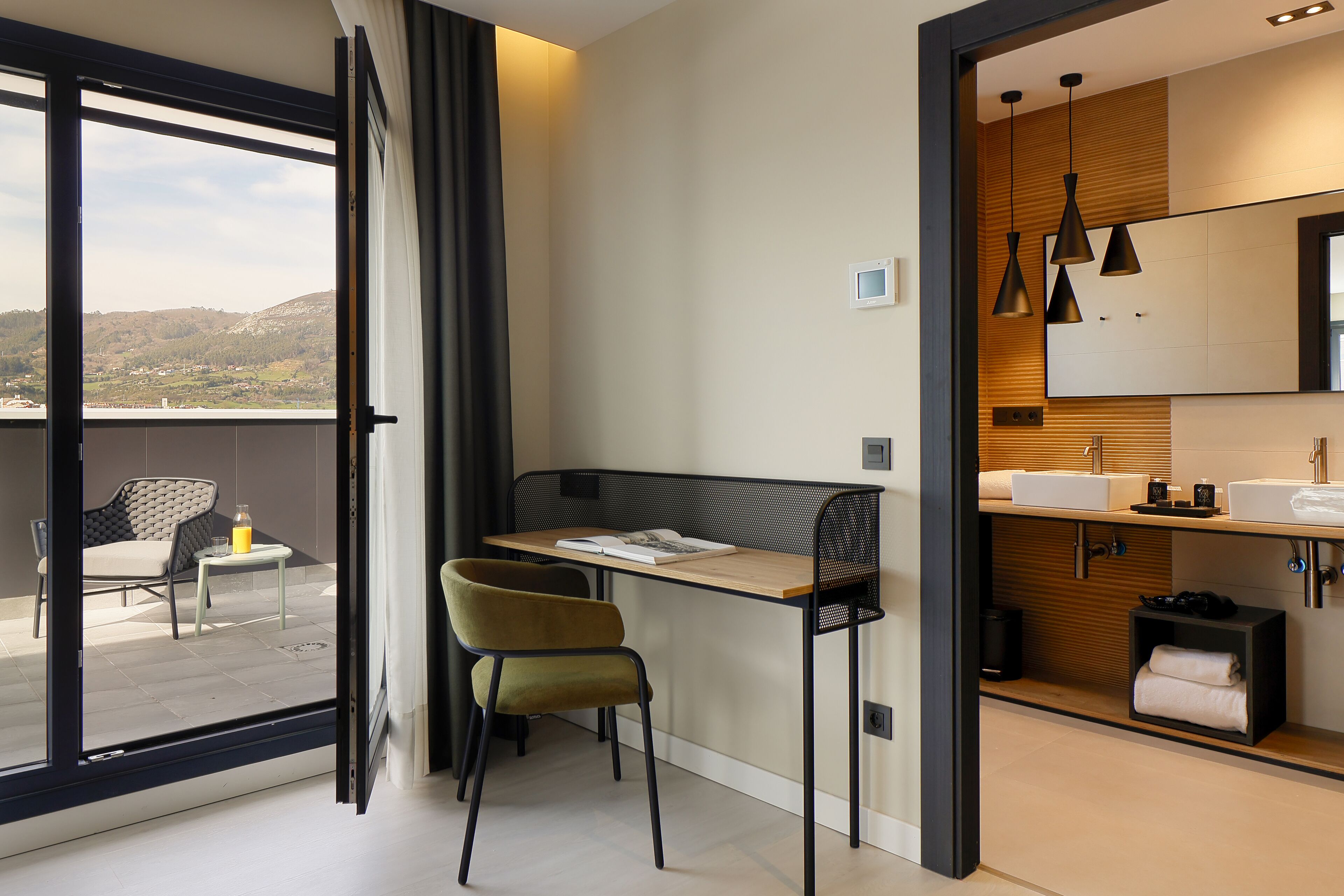 A modern bathroom with a sink, mirror, and towel storage.