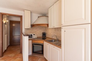 A compact kitchen with white cabinets, a microwave, a coffee maker, and a sink. - SmartStay René Payot - Chamonix-Mont-Blanc (Chamonix-Mont-Blanc)