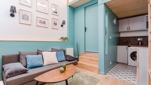 A compact living space with a sofa, coffee table, and framed pictures on the wall. - Smartstay Louis Chazette - Centre-ville (Lyon)