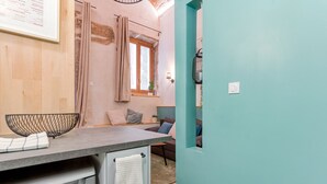 A kitchen with a countertop, a sink, and a window with curtains. - Smartstay Louis Chazette - Centre-ville (Lyon)