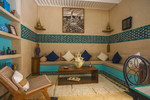 A living room with a sofa set, a coffee table, a patterned rug, and decorative items. - Riad La Rose Orientale Marrakech (Marrakech)