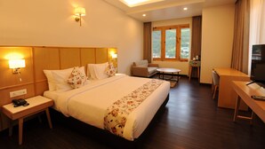 A hotel room with a large bed, bedside tables, a desk, a chair, a TV, and a window with curtains. - Thimphu Central Hotel (Thimphu)