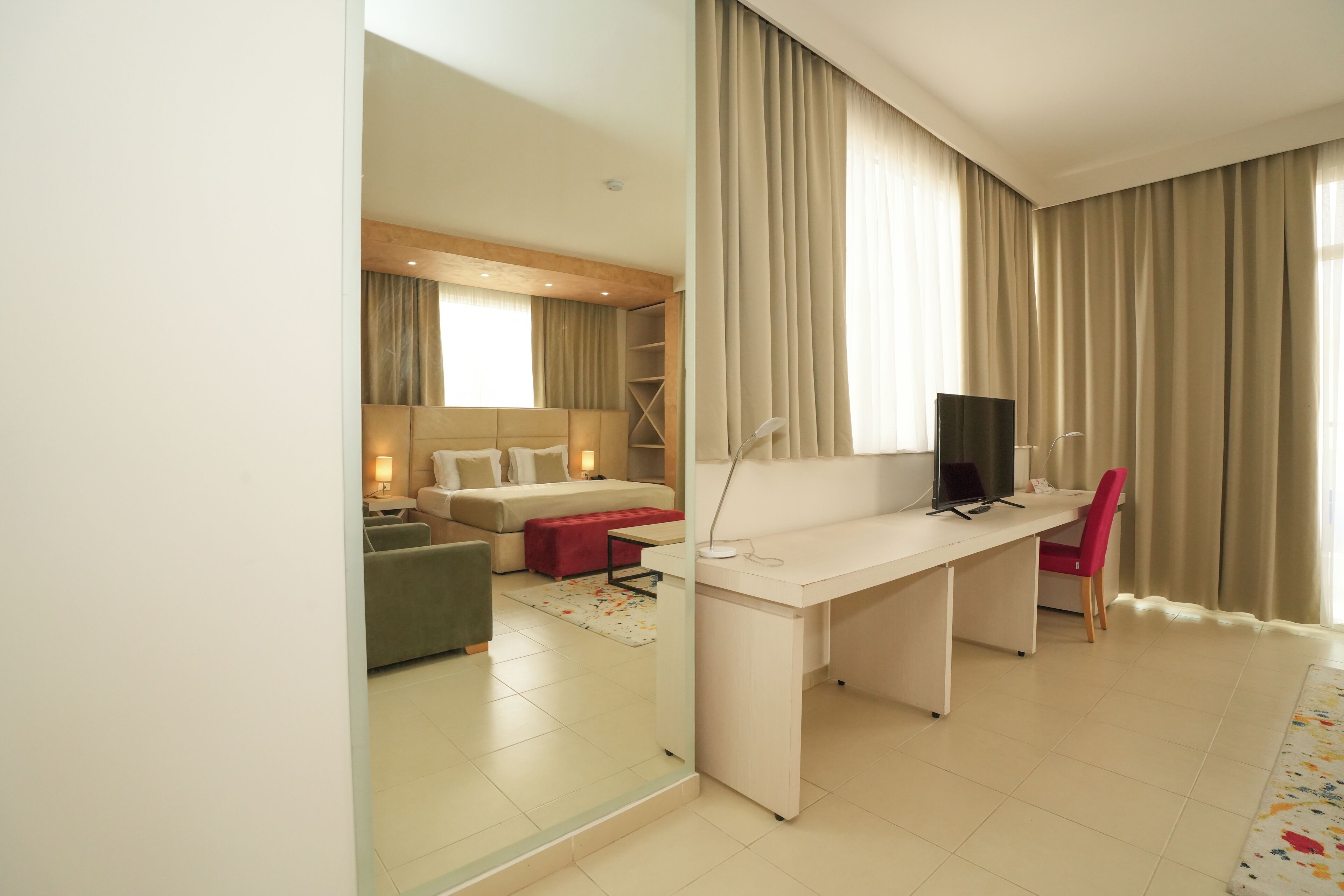 Una habitación de hotel moderna con cama, escritorio, silla y televisor.