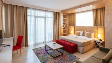 Minibar, escritorio, cortinas blackout y tabla de planchar con plancha