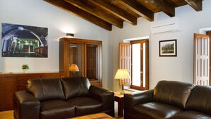 A living room with two leather sofas, a wooden coffee table, a lamp, and a painting on the wall. - La Casa del Vino (Fermoselle)