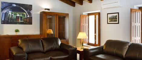 A living room with two leather sofas, a wooden coffee table, a lamp, and a painting on the wall.