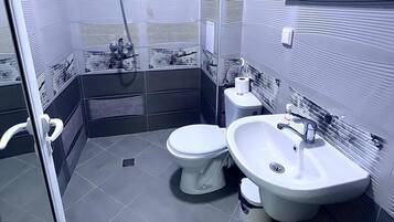 Habitación empresarial individual | Baño | Regadera, toallas, jabón, shampoo