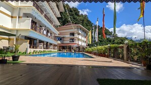 Ein Hotel mit Schwimmbad, mehreren Balkonen und Flaggen.