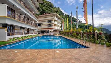 Un hotel con piscina, varios balcones y banderas.