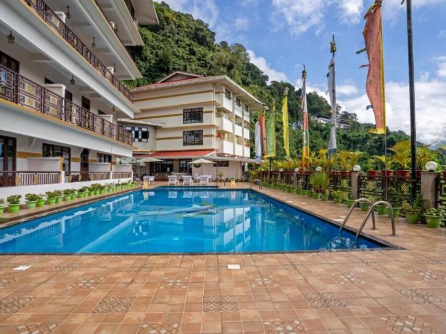 Un hotel con piscina, varios balcones y banderas.