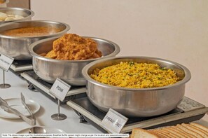 Ein Frühstücksbuffet mit gekennzeichneten Speisen, darunter Poha und Brot/geröstetes Brot.