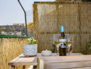 Une table avec une bouteille de vin, deux verres à vin, un pot décoratif et un petit récipient.