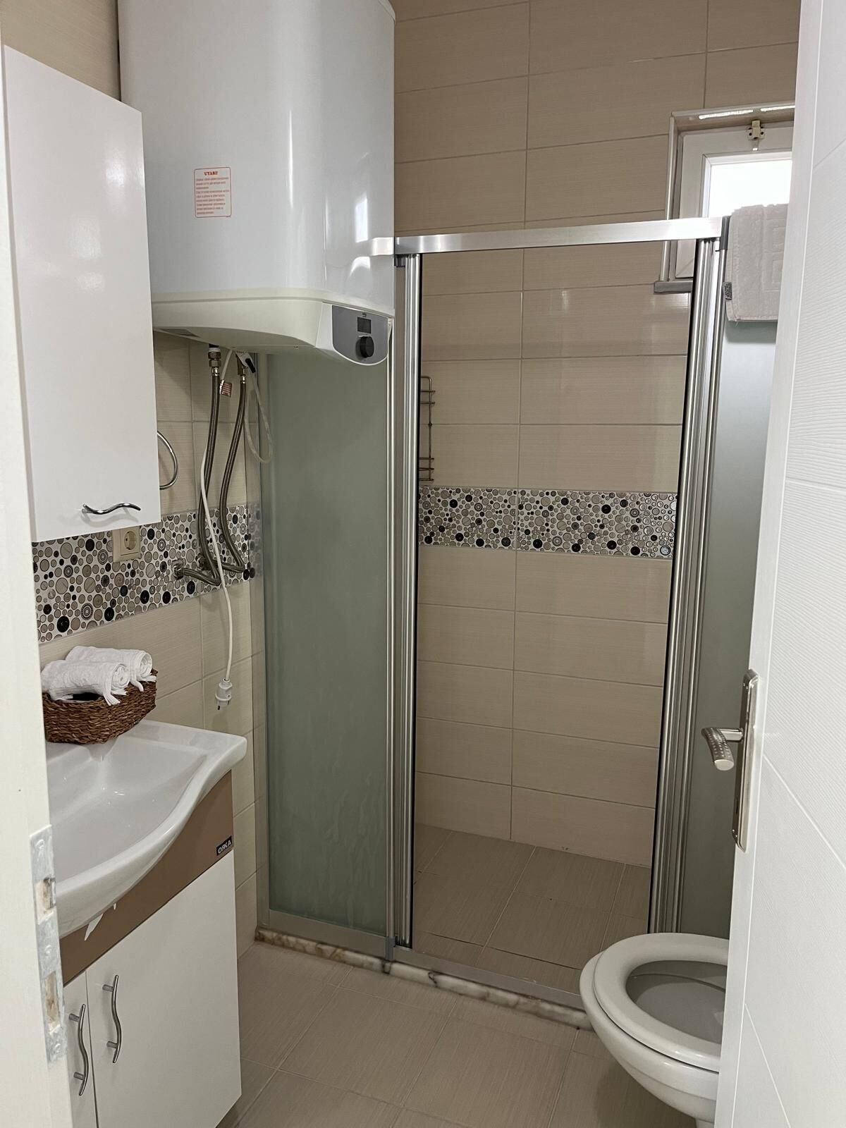 Un bany amb plat de dutxa, un lavabo i un vàter.