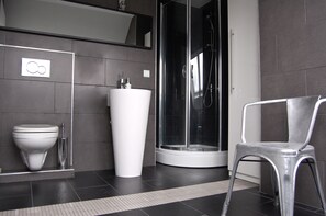 Ein modernes Badezimmer mit Toilette, Waschbecken und Dusche.