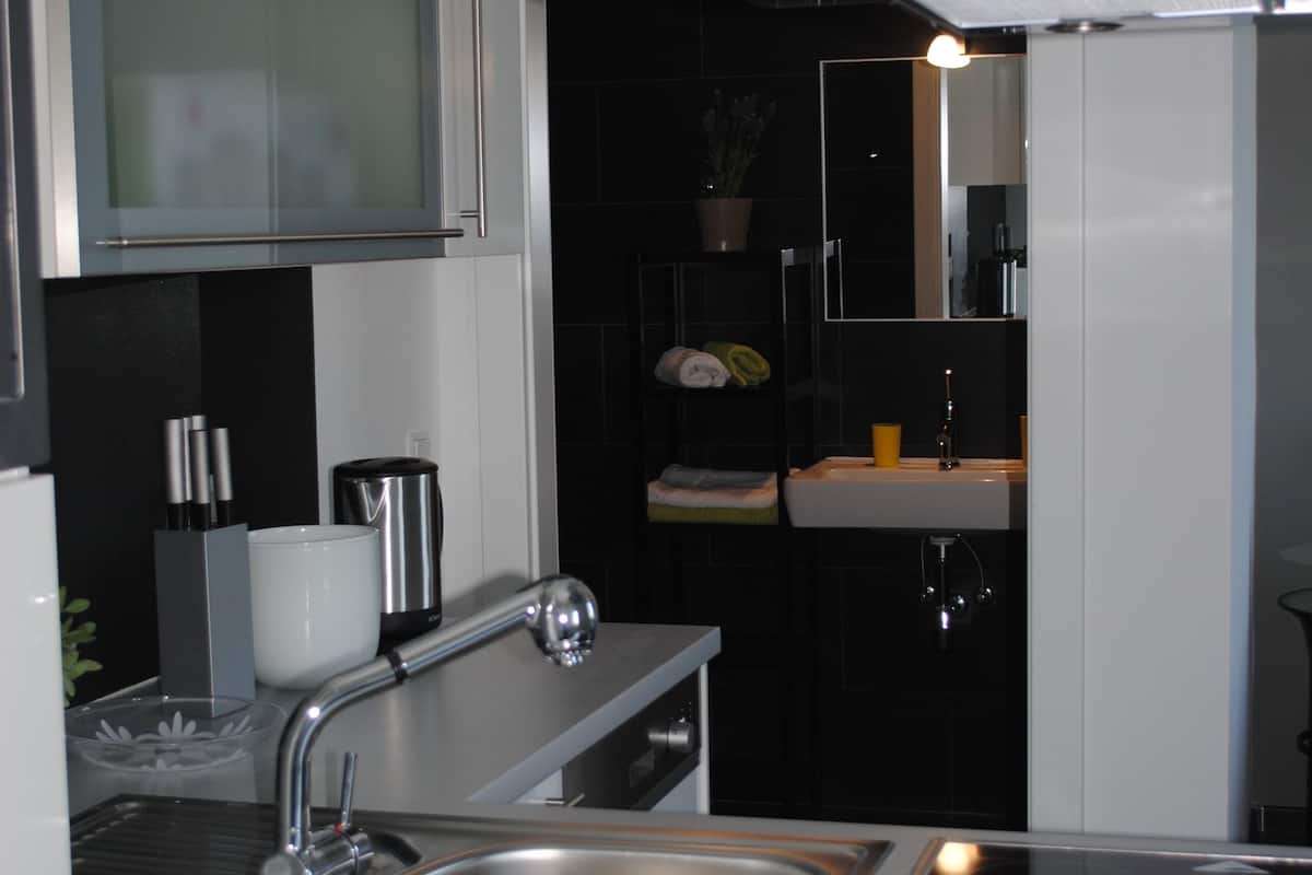 A modern kitchen with stainless steel appliances, a sink, and a countertop.