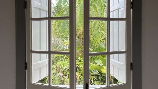 A bay window with multiple panes, offering a view of lush greenery outside. - Hotel Boutique Casa Arte Cabore (Paraty)