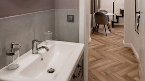Ein modernes Badezimmer mit großem Spiegel, Waschtisch und Spüle.