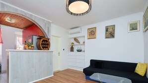 A modern living room with a wooden floor, a glass coffee table, a black sofa, and a wooden wine rack. - Lima central Old city (Dubrovnik)