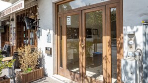 Een gebouw met een grote houten deur, terras en een bord waarop staat 'Golden River Bistrot'.