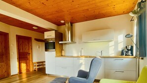 Una cocina moderna con armarios blancos, una campana de acero inoxidable y una cafetera en la encimera.