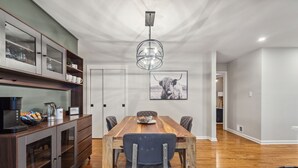 A dining area with a wooden table, chairs, a coffee station, and a wall-mounted picture. - Spacious Smyrna Retreat with 3 Kitchens for Groups (Smyrna)