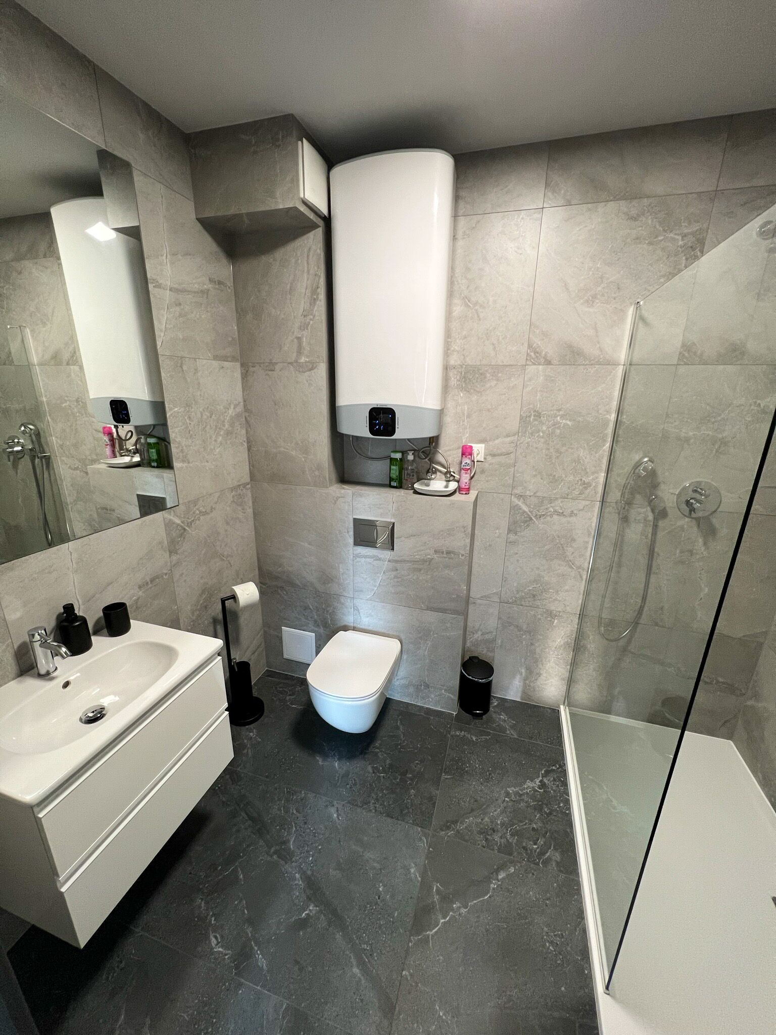 Une salle de bain moderne équipée de toilettes, d’un lavabo et d’une douche.