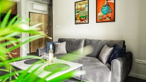 Una sala de estar moderna con un sofá gris, una mesa de centro con adornos y dos obras de arte enmarcadas en la pared.