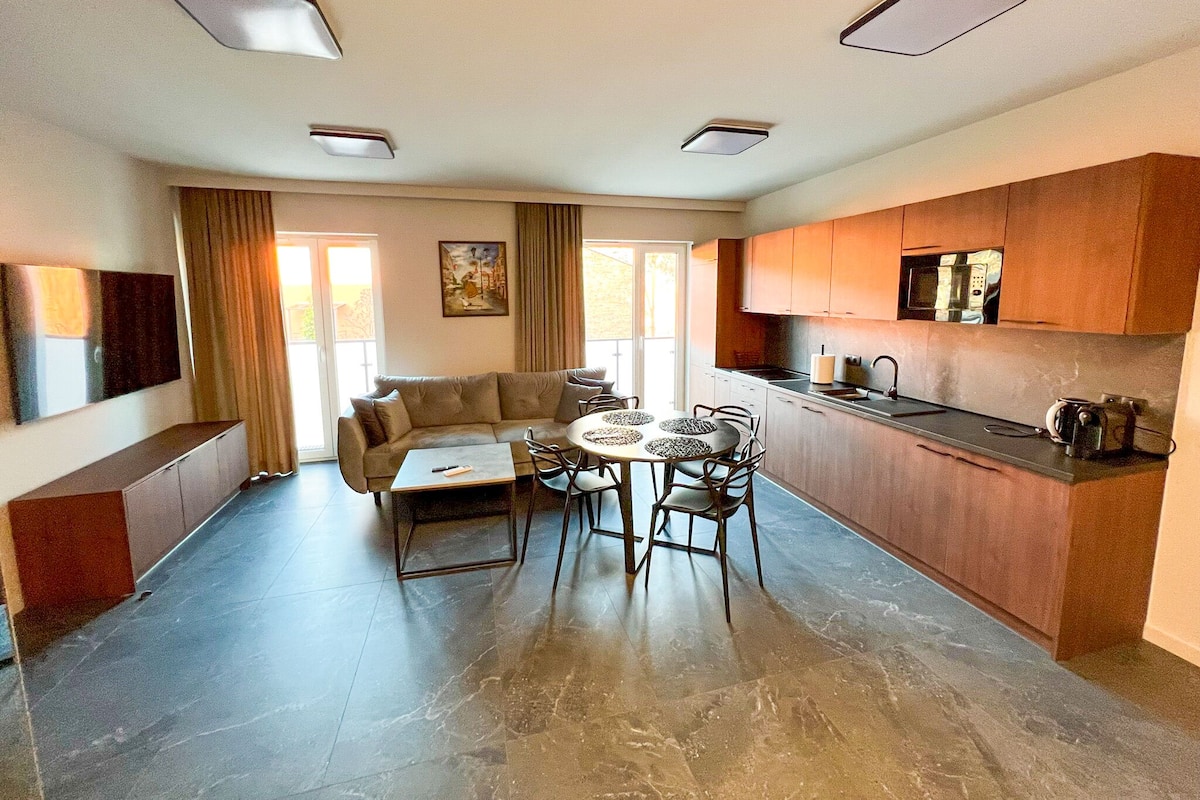 Een moderne keuken met een eethoek, inclusief een bank, tafel en stoelen.