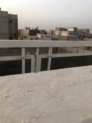 Enjoy panoramic views of the city from this rooftop terrace with a flat surface and simple railing.