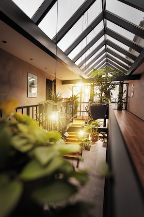 A modern interior with a skylight, wooden flooring, and potted plants. - Das Metzgerbräu (Hohenwart)