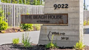 A concrete sign with the number 9022 and the text "THE BEACH HOUSE at Saratoga Villas 1-17 30-31".
