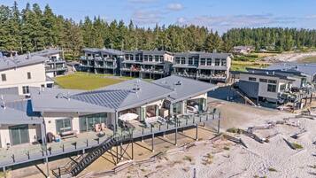 Ein Küstenhotel mit mehreren Gebäuden, Sitzbereichen im Freien und Blick auf den Strand.