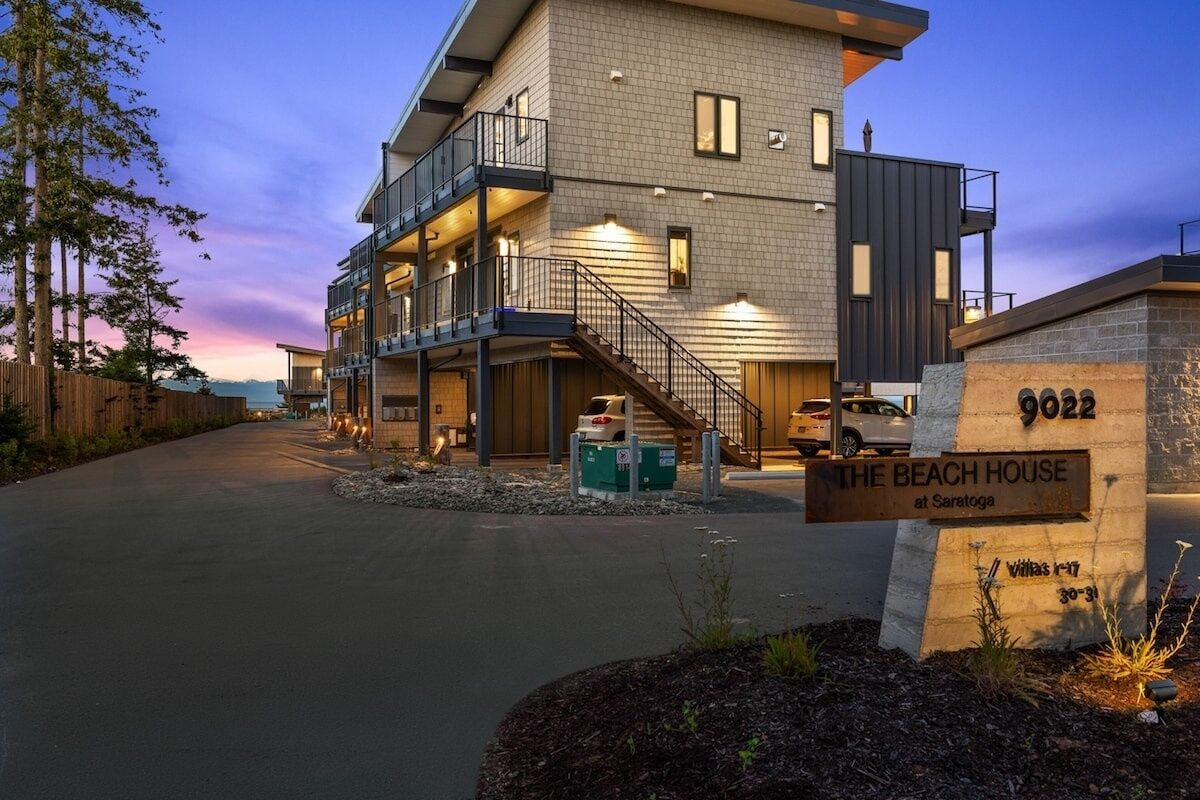 A modern multi-story building with a balcony, labeled "The Beach House at Saratoga."