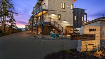 A modern multi-story building with a balcony, labeled "The Beach House at Saratoga."