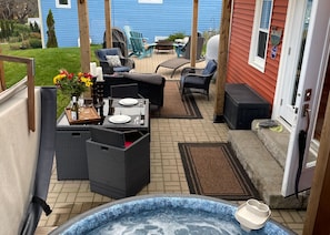 A patio area with outdoor furniture, a hot tub, and a view of the backyard.