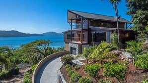 Une maison moderne à deux étages dotée d’un balcon offrant une vue sur la côte.