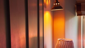 A bedroom with a bed, pillows, a lamp, and a window. - The Plough Inn (Lechlade)