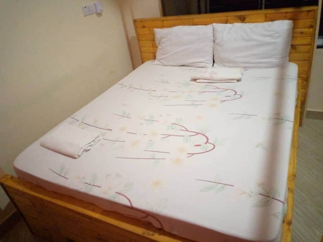 A bed with a floral bedspread and two pillows.