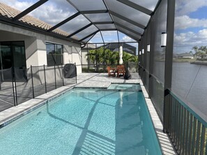 Outdoor pool, a heated pool - Stunning new construction 4-bedroom home with a Heated Pool and Spa on a Canal (Cape Coral)