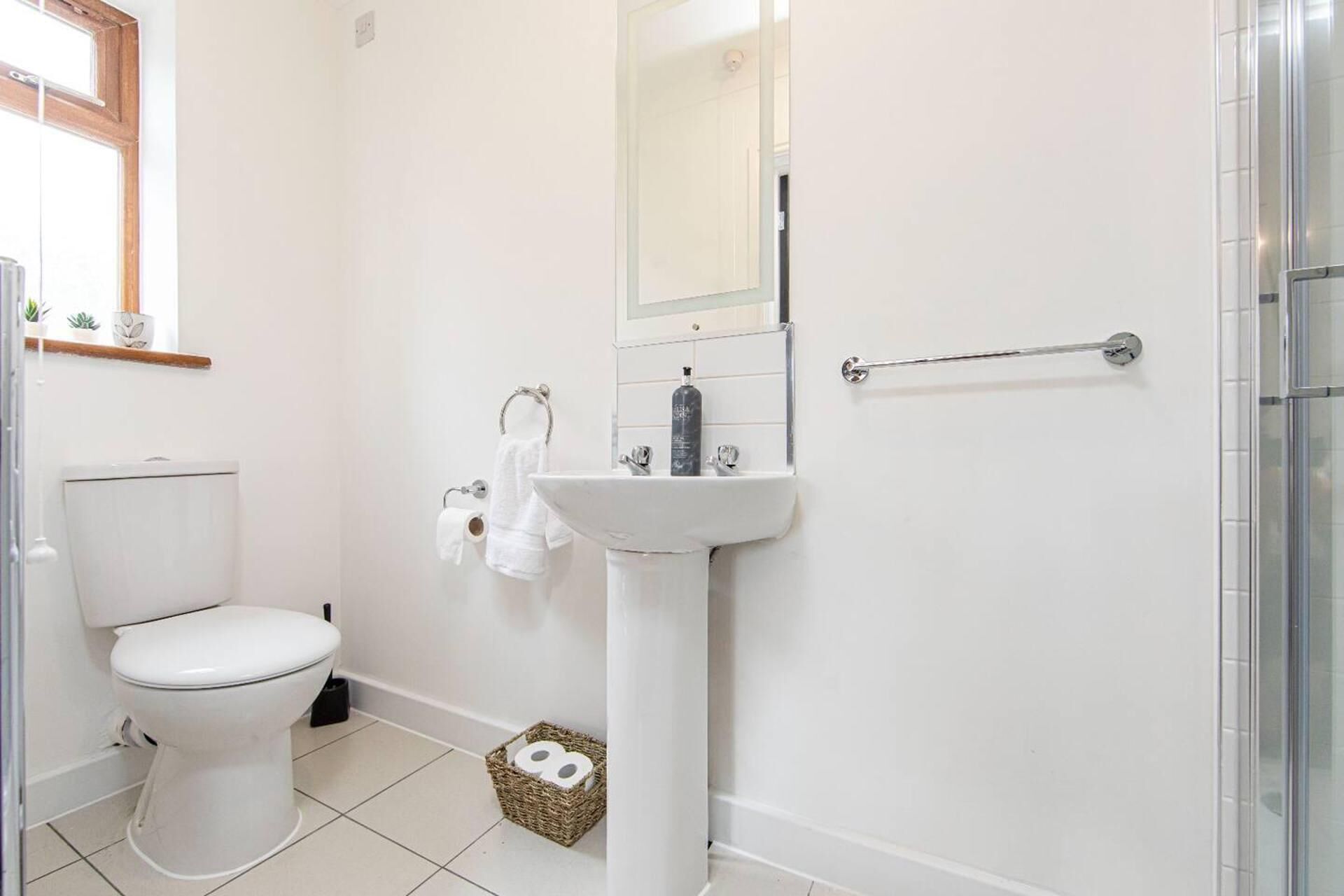 A bathroom with a toilet, sink, and shower.