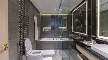 Un bagno moderno con doccia vetrata, una vasca da bagno ampia e un WC separato.