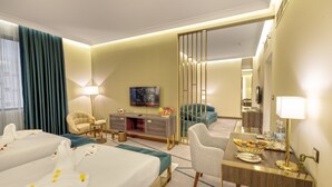 A hotel room with two beds, a desk, a chair, a television, and a large mirror. - Green Park Hotel (Doha)