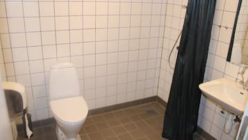 A bathroom with a toilet, a sink, and a shower curtain.
