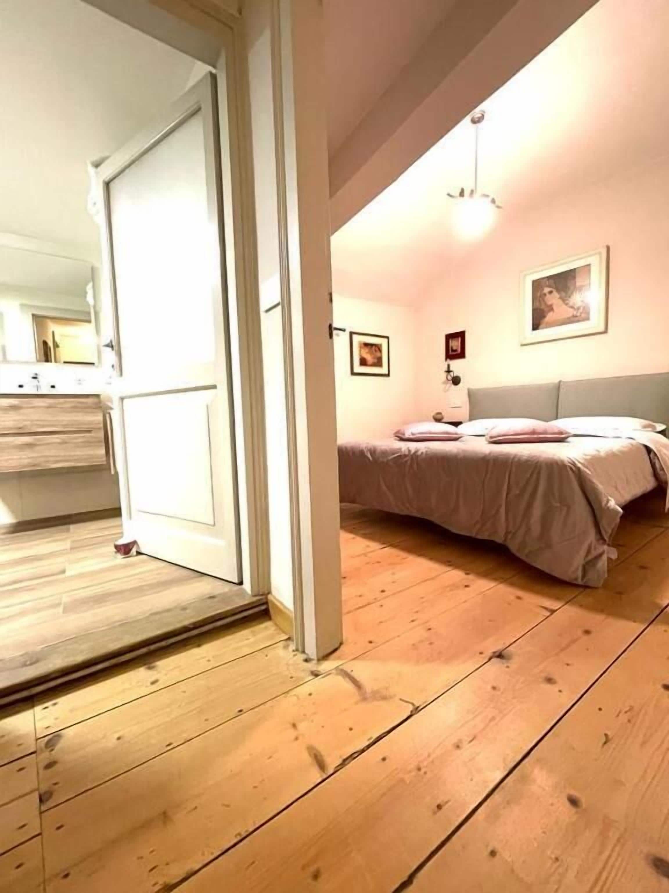 Ein Schlafzimmer mit einem Bett, einem Nachttisch und einer Wandleuchte.