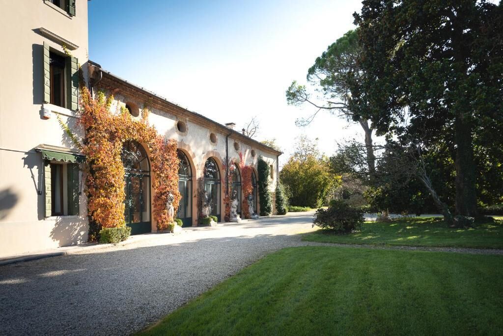 Un edificio con una tettoia, finestre ad arco e colonne ricoperte d'edera.