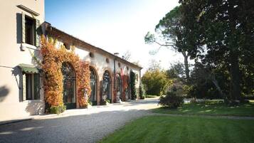 Un edificio con una tettoia, finestre ad arco e colonne ricoperte d'edera.