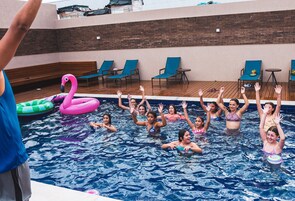 Una piscina al aire libre, sombrillas, sillones reclinables de piscina