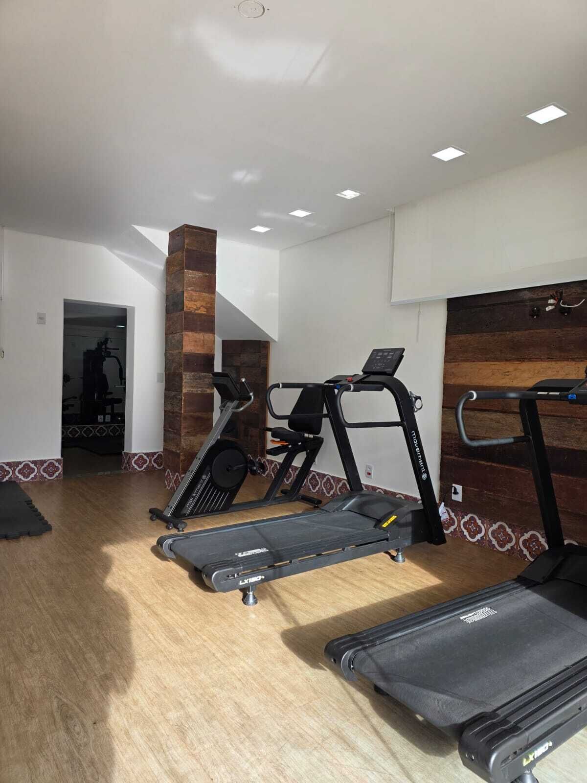 A gym with treadmills, a stationary bike, and a weight bench.