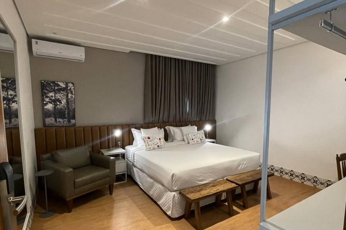 Une chambre à coucher comprenant un lit, un canapé, une table de chevet et une chaise.